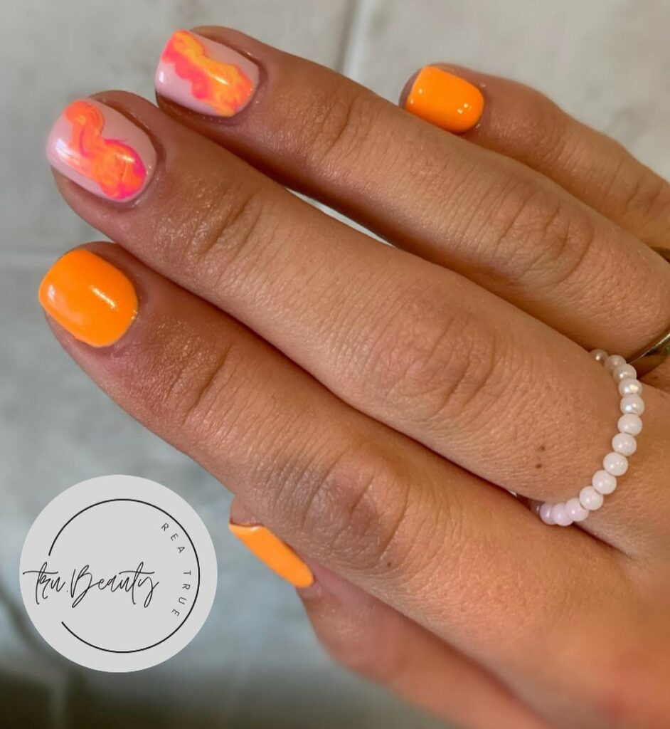 Bright orange gel nails with nail art